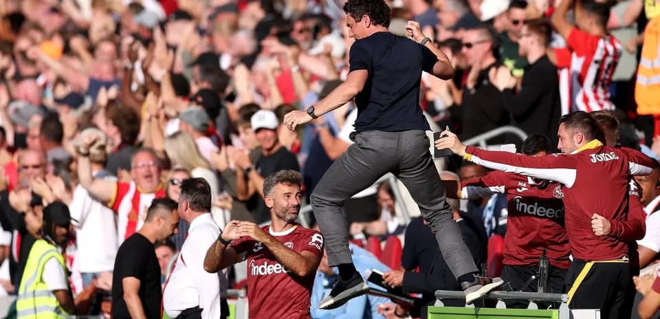 Coach celebrating with fans during match excitement