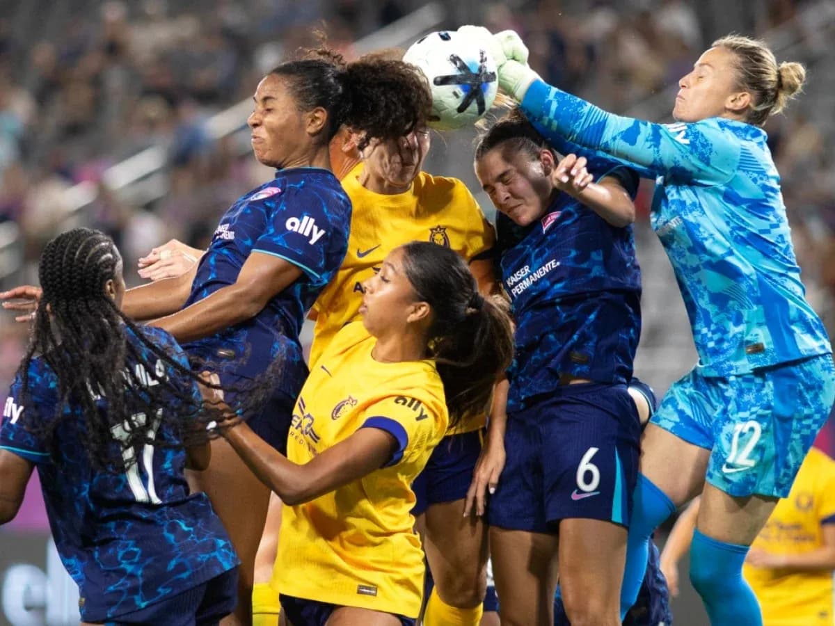 Players contesting a high ball in NWSL match