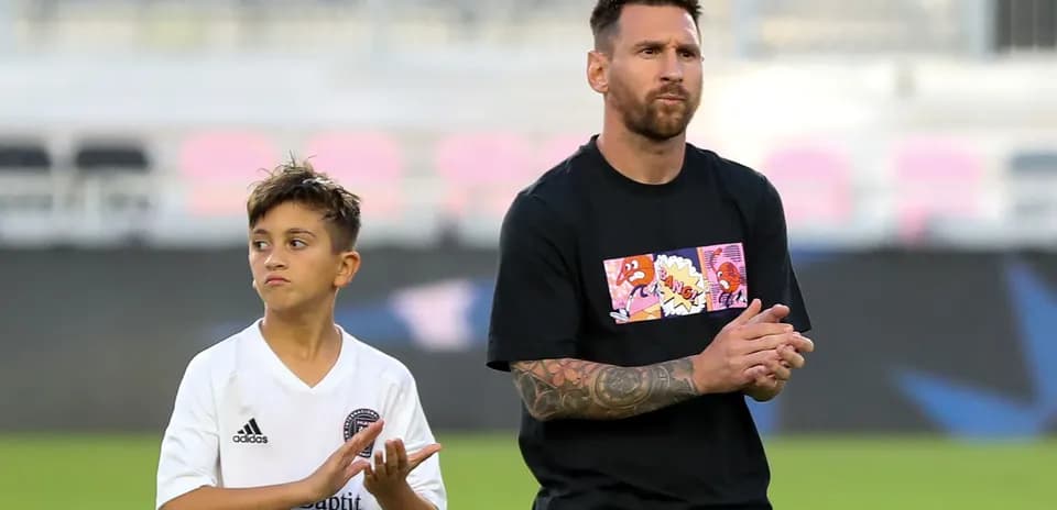 Lionel Messi and a child applauding on field