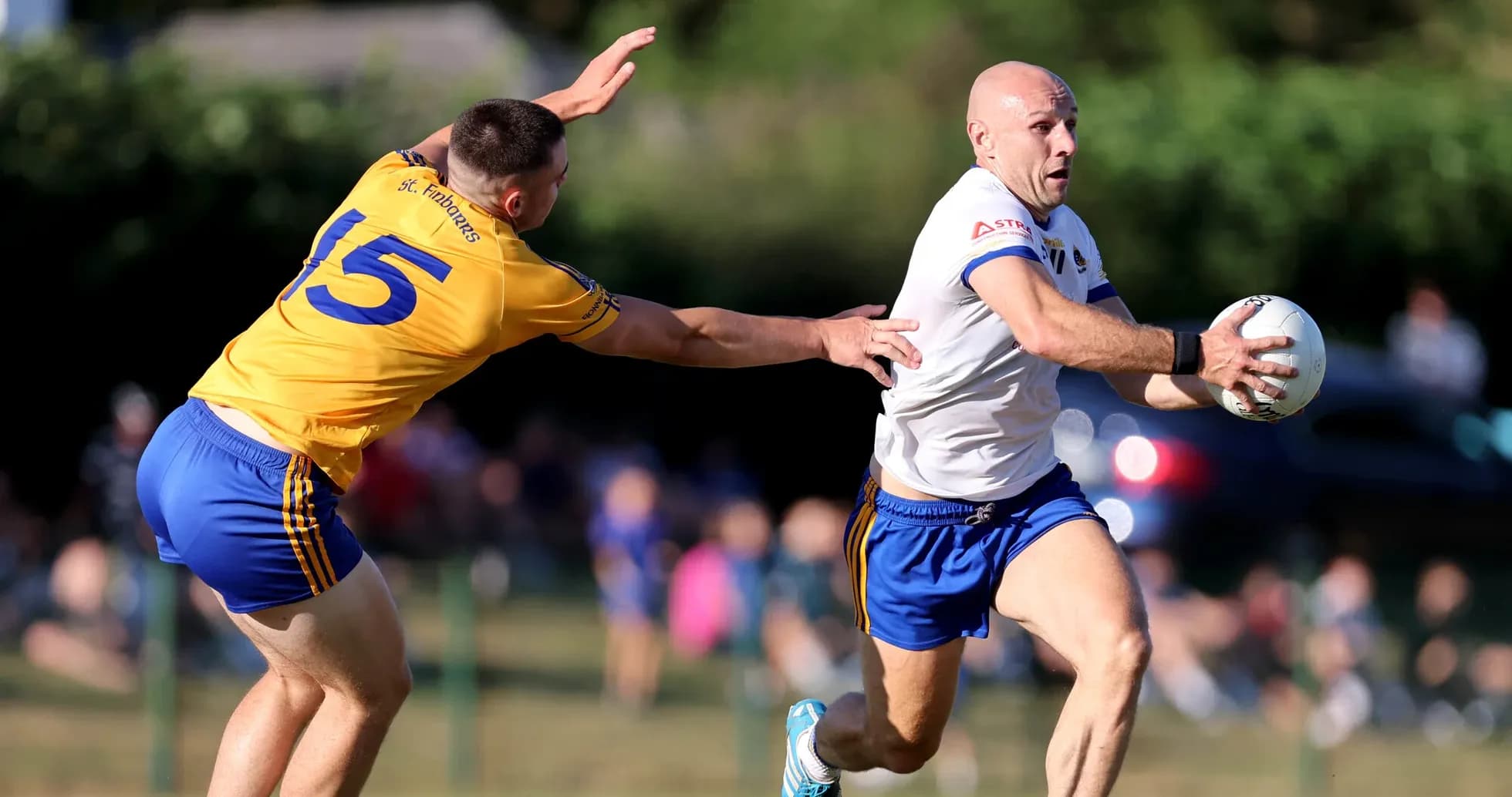 Player in white evading tackle while holding ball