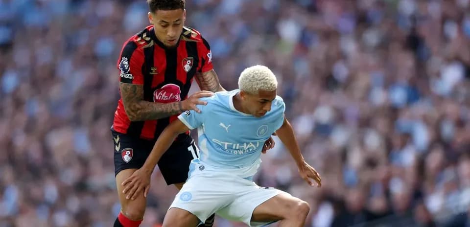 Bournemouth player challenges Manchester City player for ball