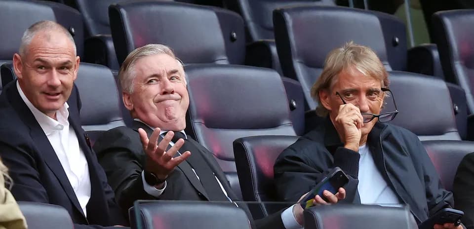 Three men seated in a stadium viewing area