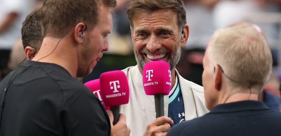Three commentators holding microphones during interview
