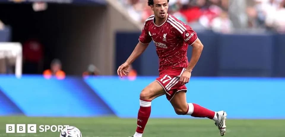 Player in red Liverpool kit running with ball