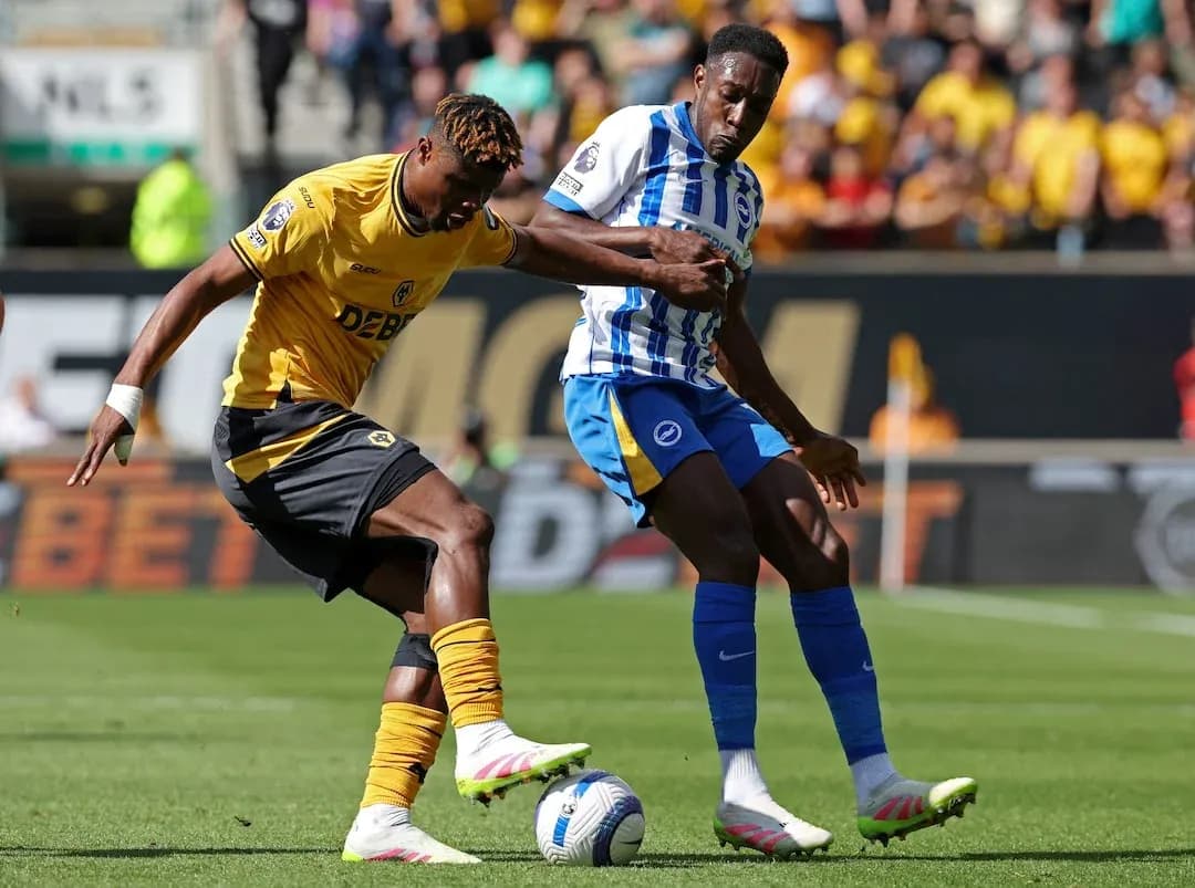 Brighton player challenging Wolves player for ball