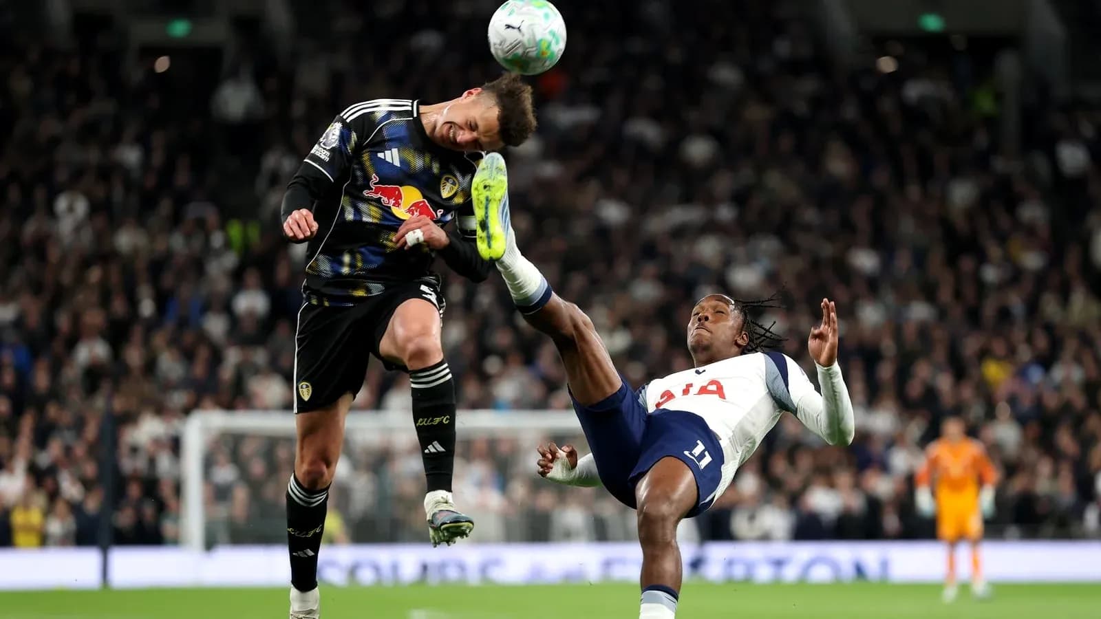 Goalkeeper jumping to avoid opposing player's kick