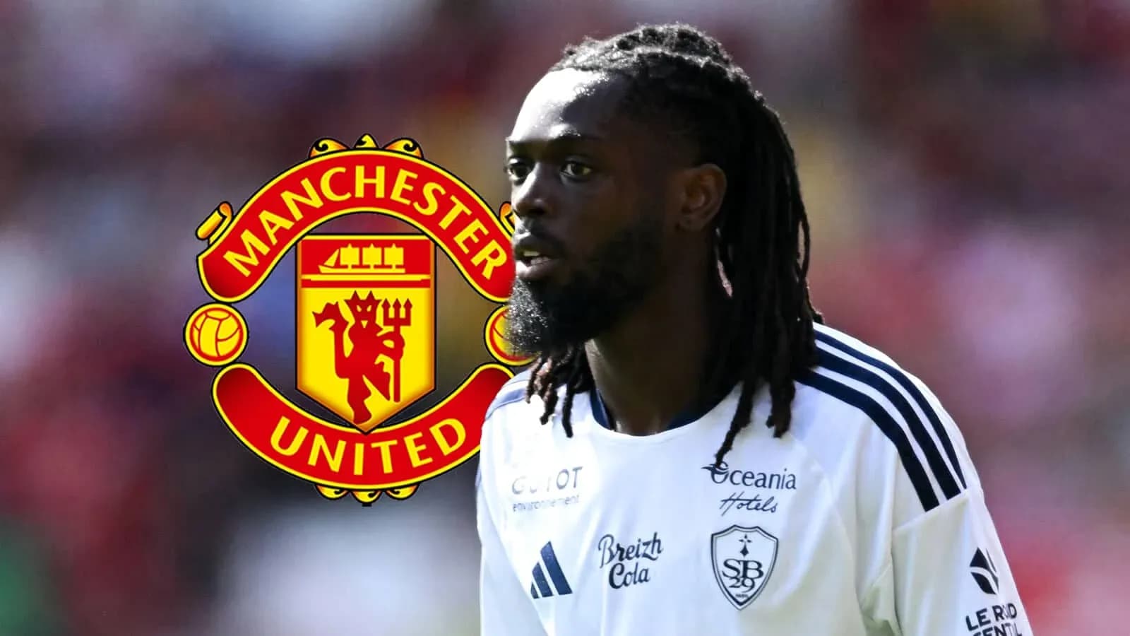 Player in white kit with Manchester United logo background