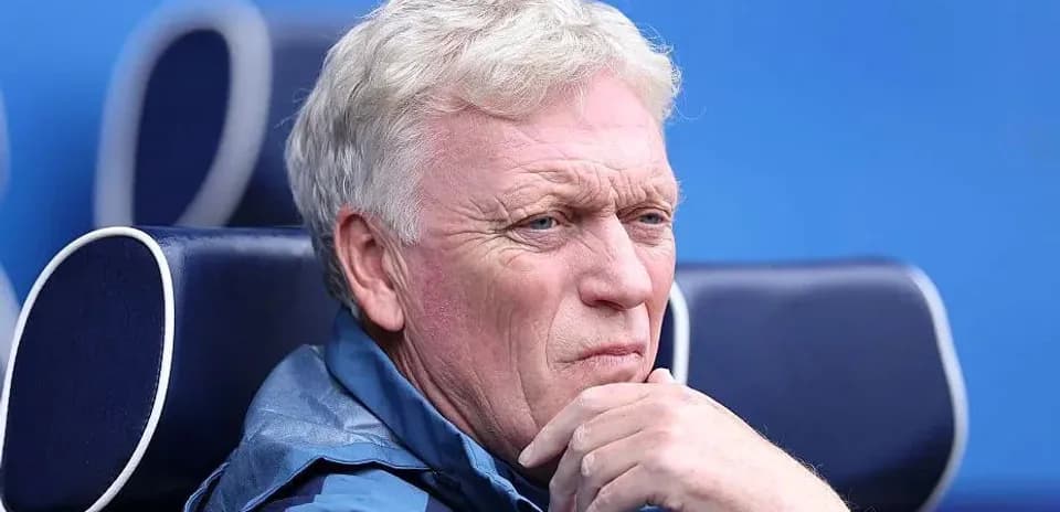 Coach sitting thoughtfully on the sidelines