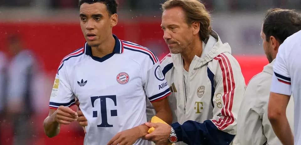 Bayern Munich player interacting with coach on sidelines