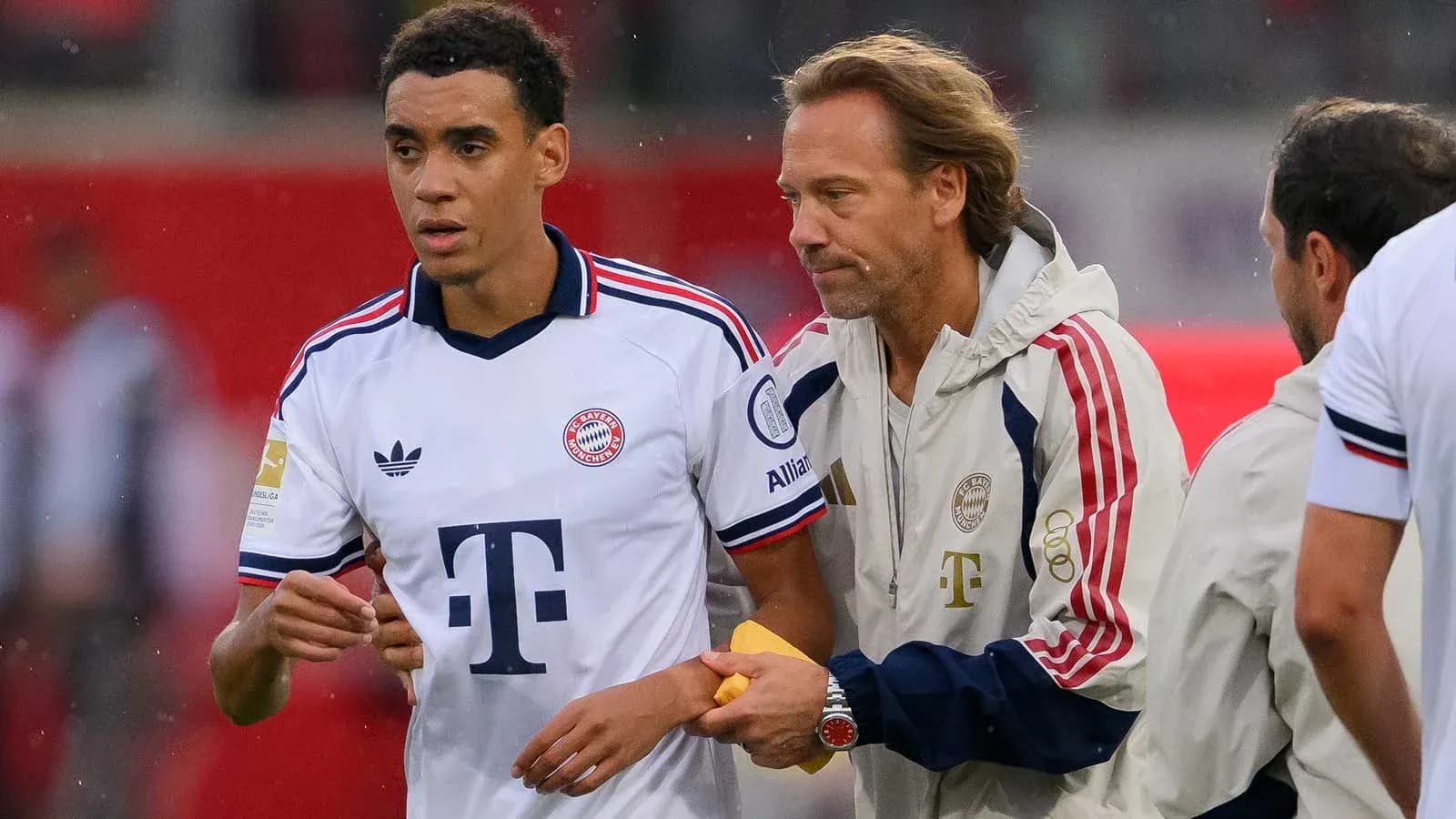 Bayern Munich player interacting with coach on sidelines