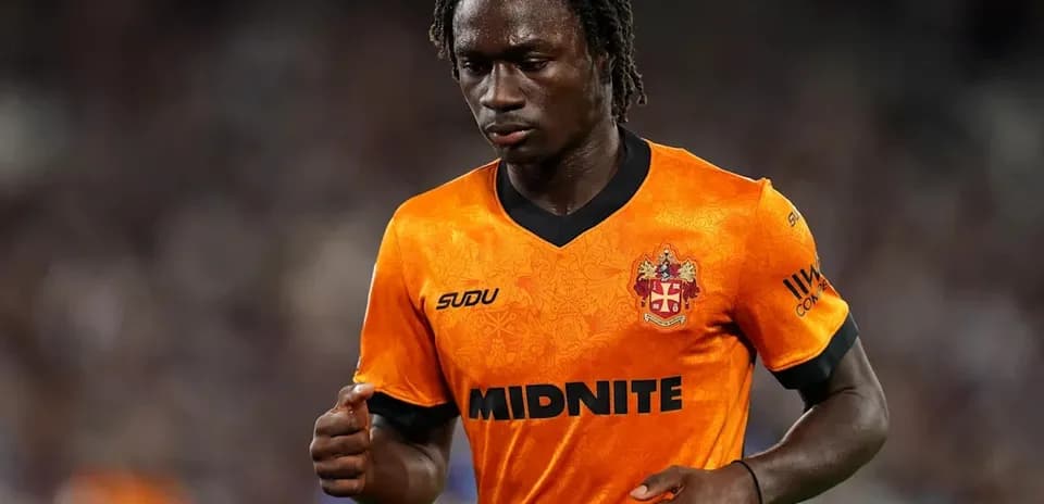 Player in orange jersey walking on the pitch
