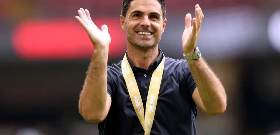 Coach celebrating with hands raised at event