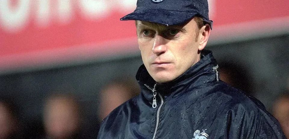Coach in rain jacket during match observation