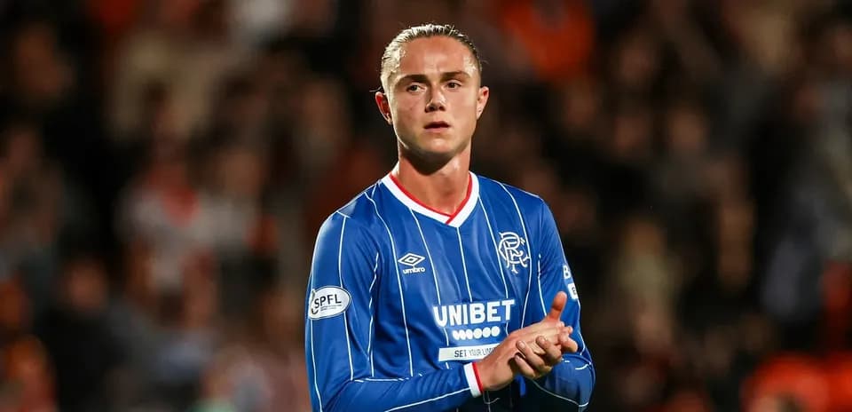 Player in blue jersey applauding fans at stadium