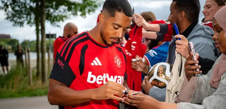 Player signing autographs for fans outside