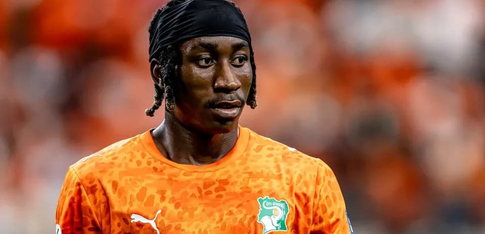 Goalkeeper in orange jersey during match warm-up