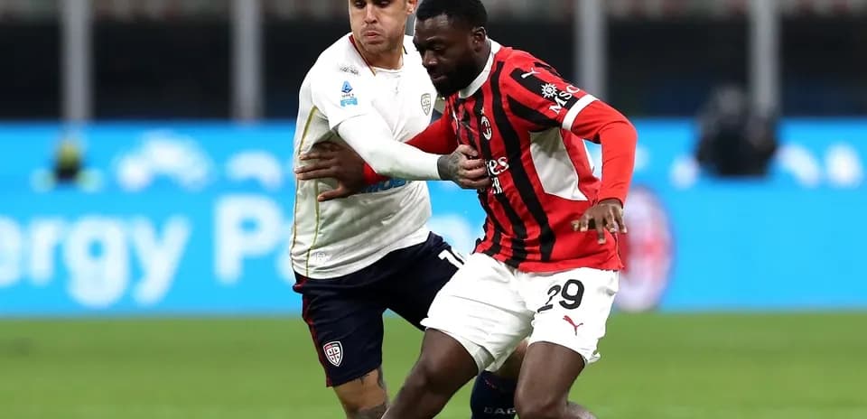 AC Milan player battling with Cagliari opponent