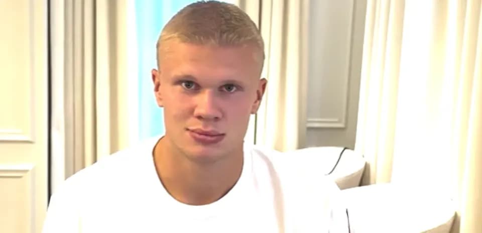 Young man sitting indoors wearing a white shirt