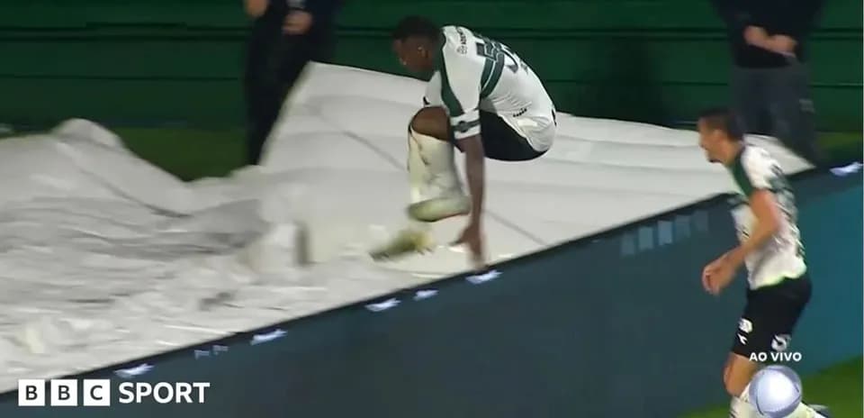 Player jumping over advertising board during match