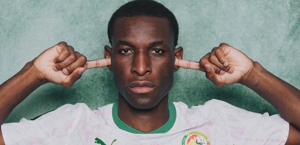 Player in Senegal jersey covering ears with hands