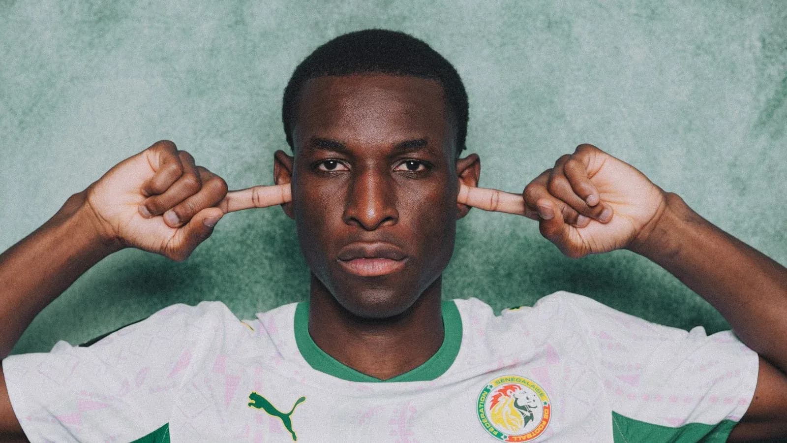 Player in Senegal jersey covering ears with hands
