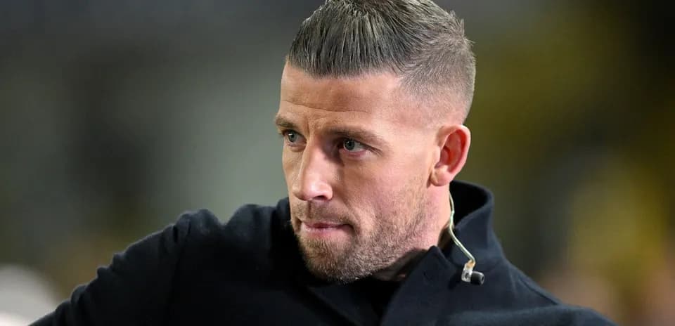 Man in dark coat looking intently at event