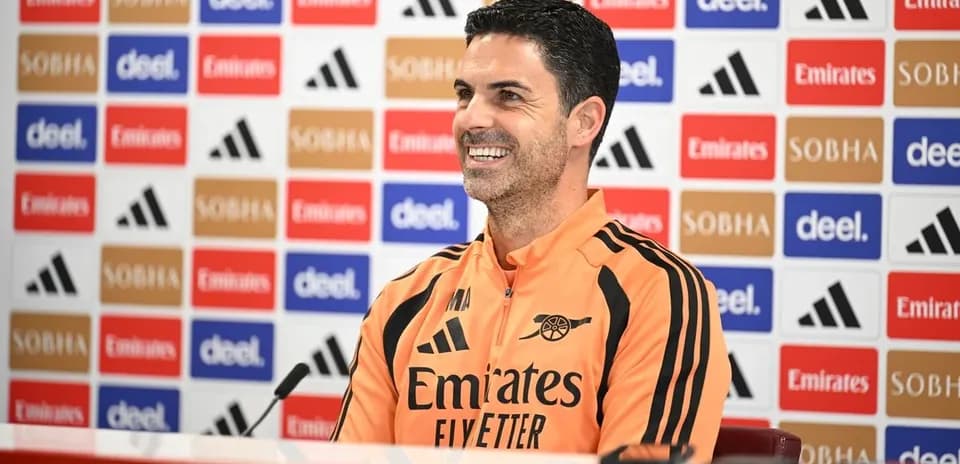 Manager speaking at press conference with sponsor backdrop