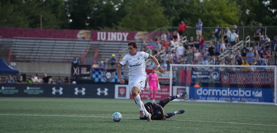 Player dribbling past opponent during match