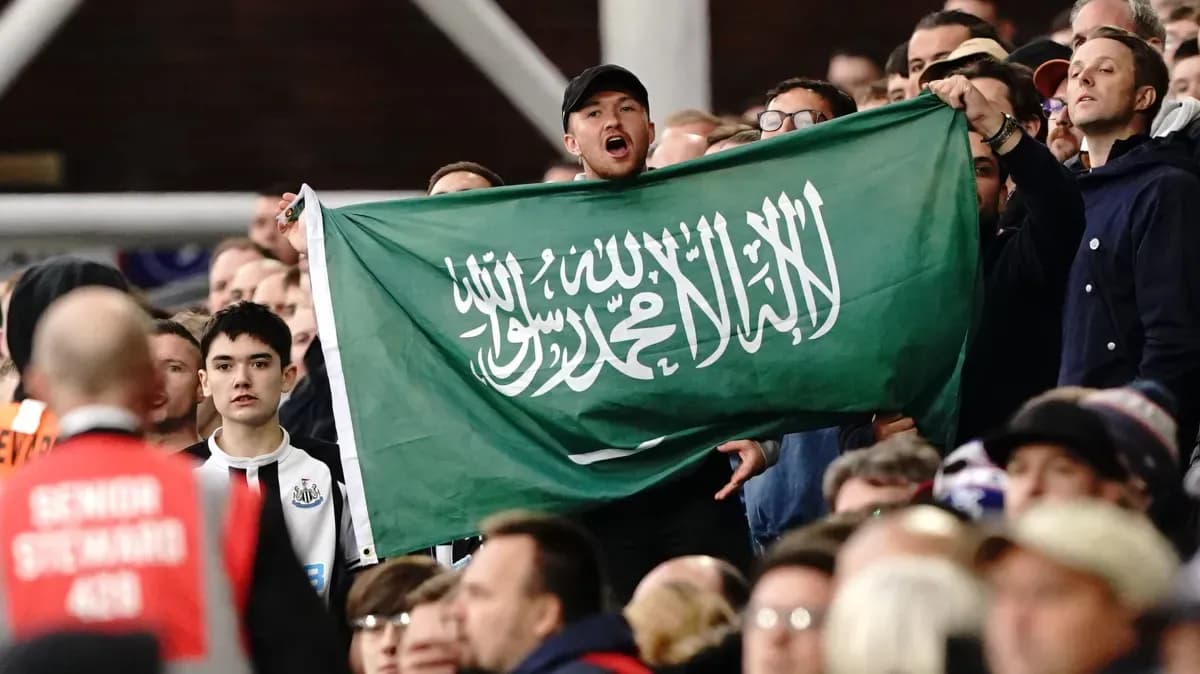 Fan holding Saudi Arabia flag in the crowd