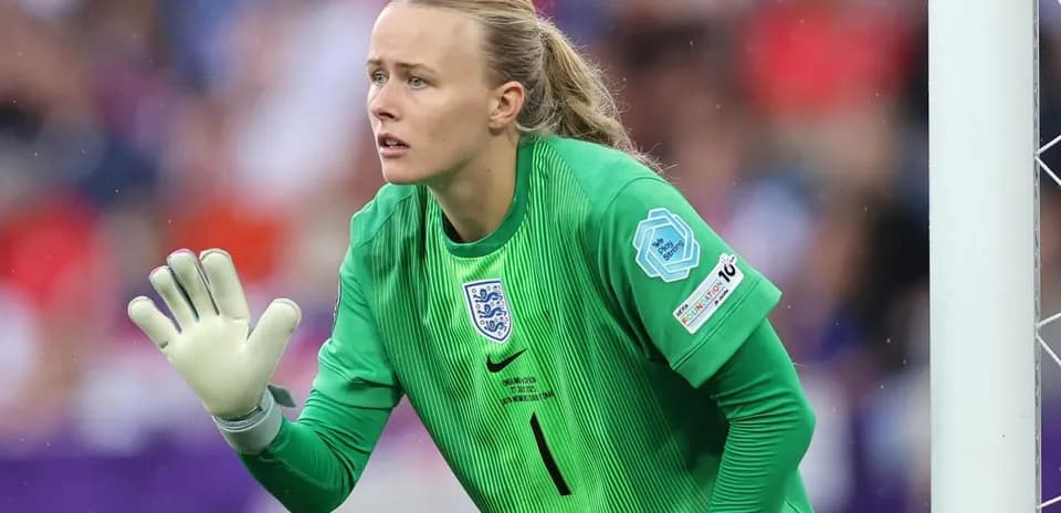 Goalkeeper in green uniform signaling during match