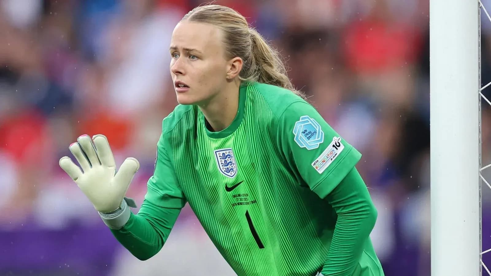 Goalkeeper in green uniform signaling during match