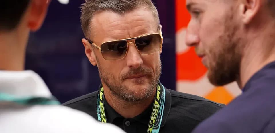Man wearing sunglasses speaking with two others