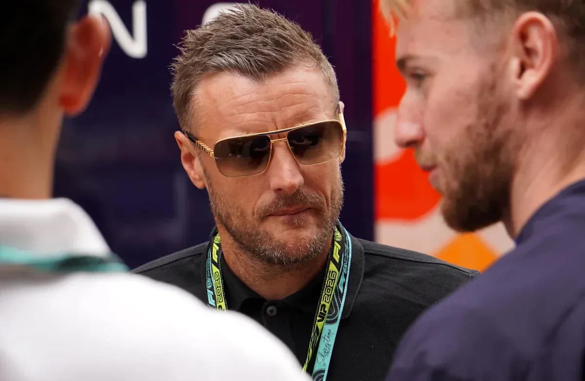 Man wearing sunglasses speaking with two others