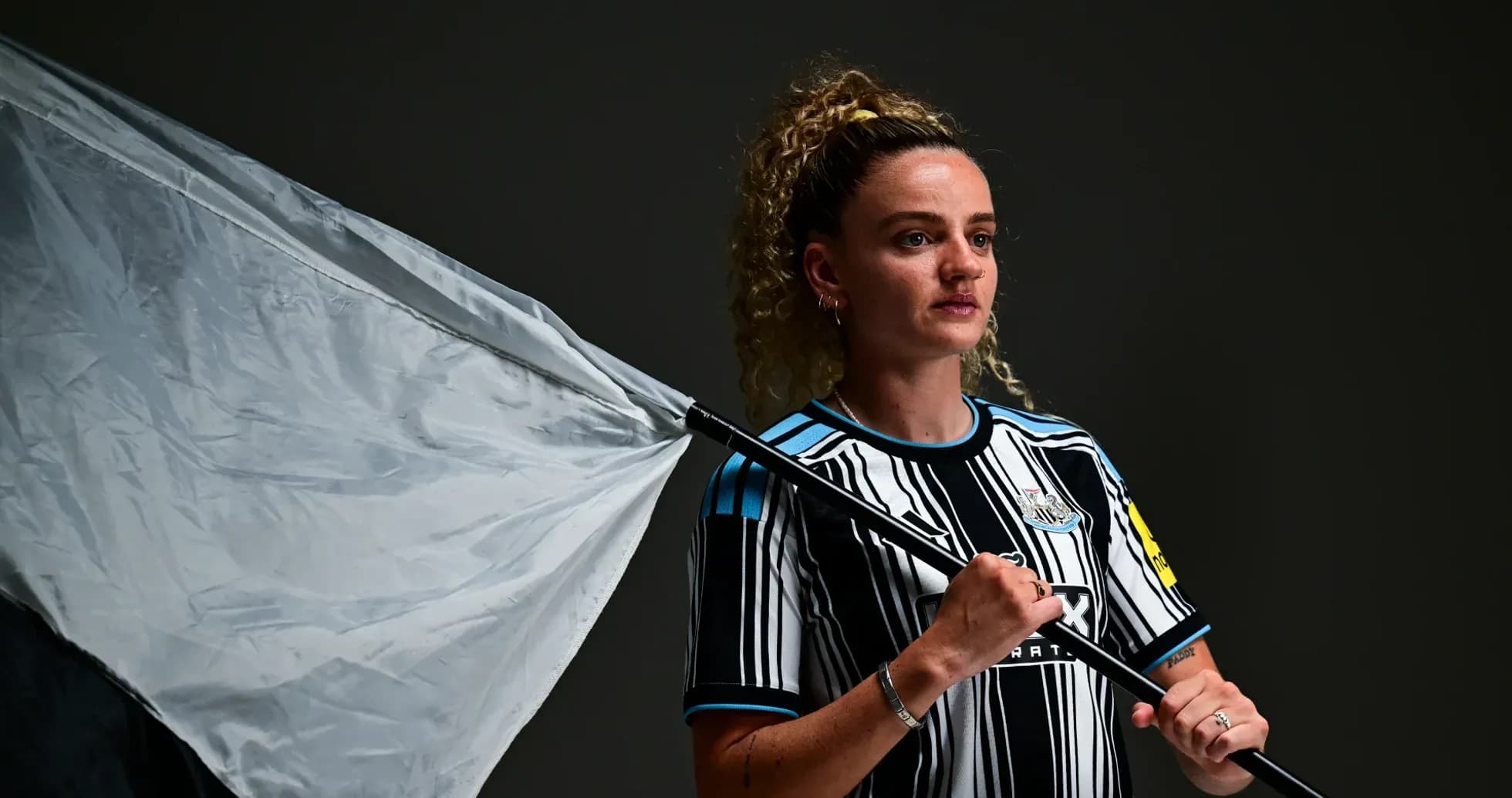 Player holding a flag in Newcastle jersey