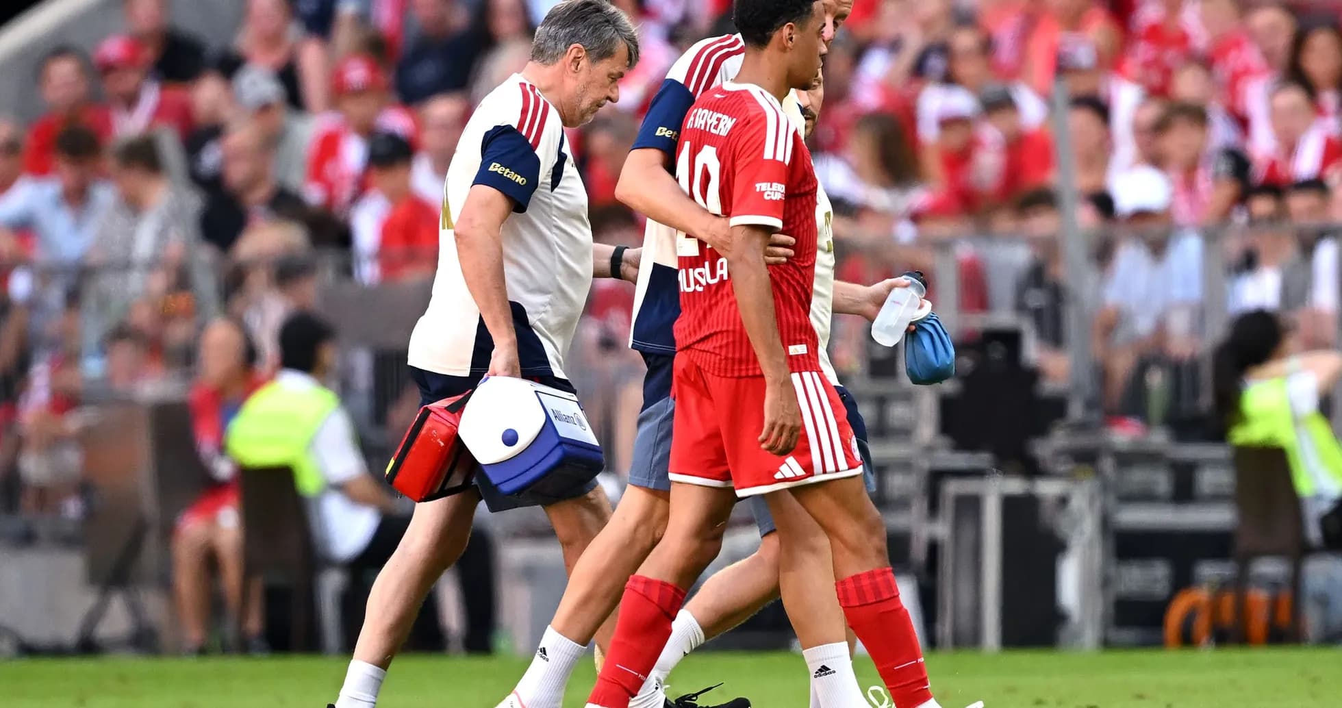 Player being assisted off the field by medical staff
