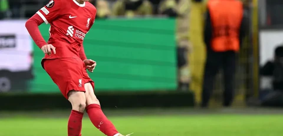 Player kicking ball during match for Liverpool