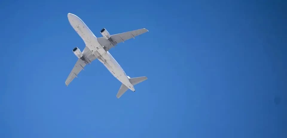 Commercial airplane flying against clear blue sky