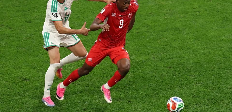 Player from Switzerland evading Algerian defender