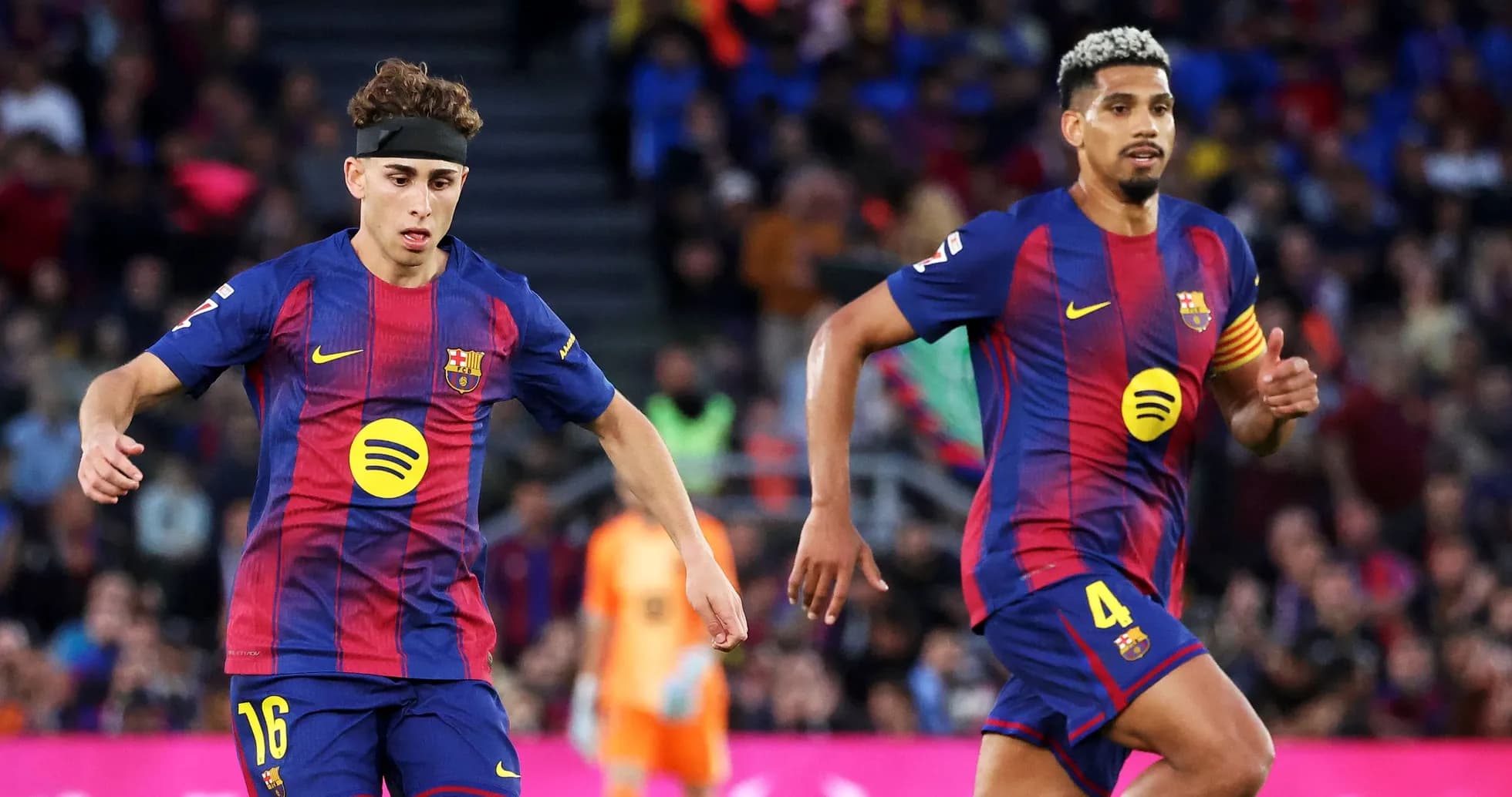 Two FC Barcelona players running during a match