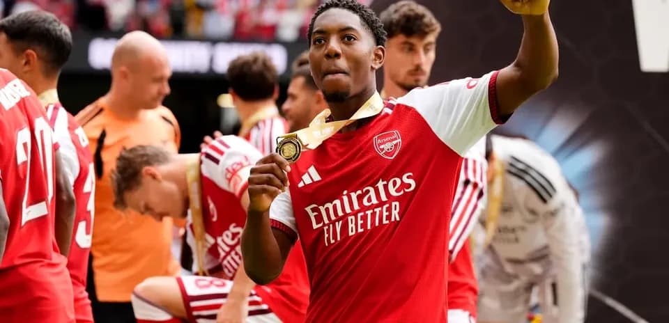 Arsenal player celebrating with medal after match