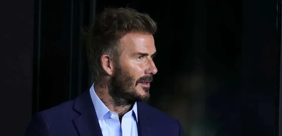 Man with tattoos in a suit speaking at event