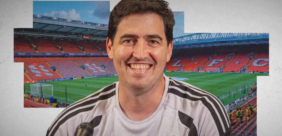 Man smiling in front of Anfield stadium background