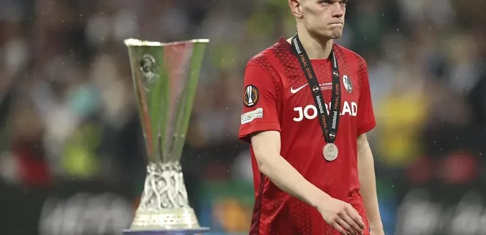 Player walking past UEFA trophy after match
