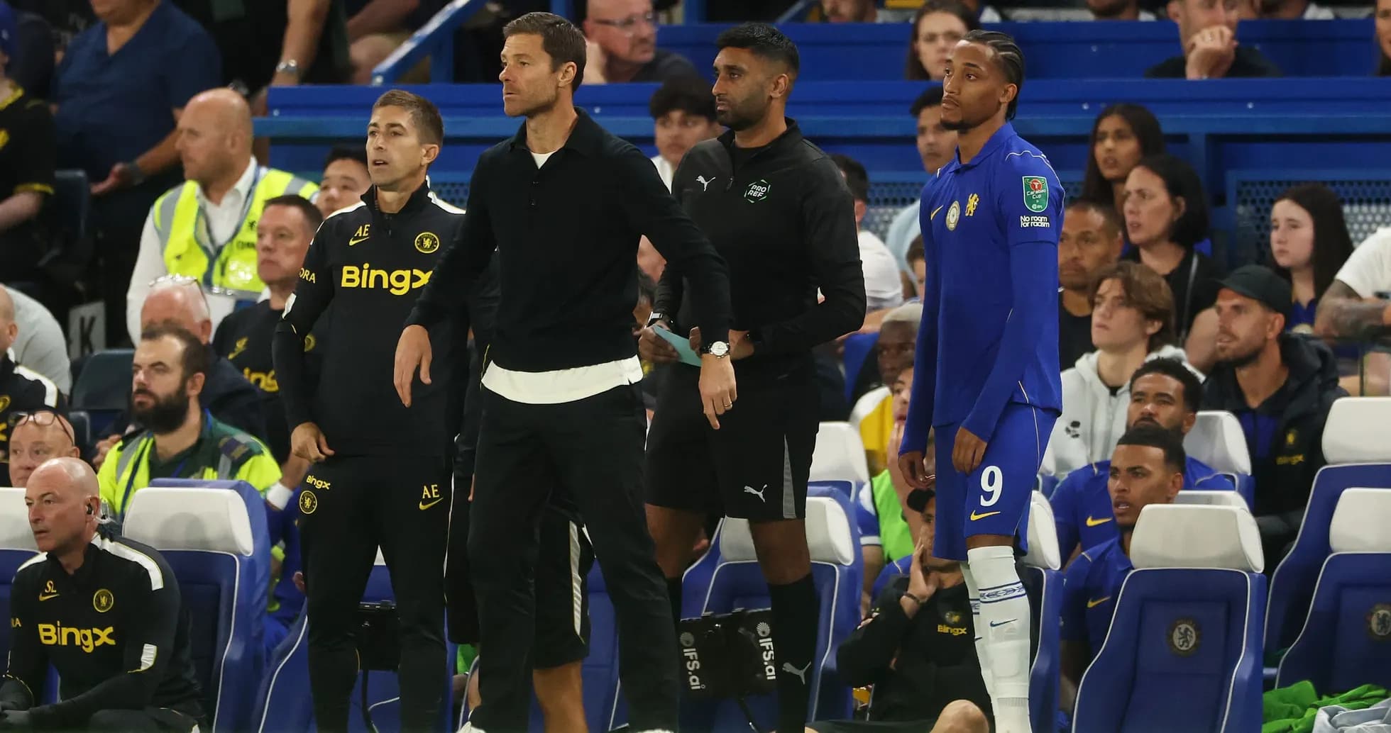 Coaches and players on bench during match