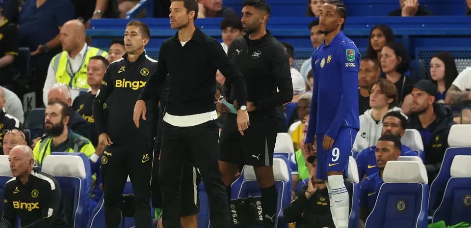 Coaches and players on bench during match
