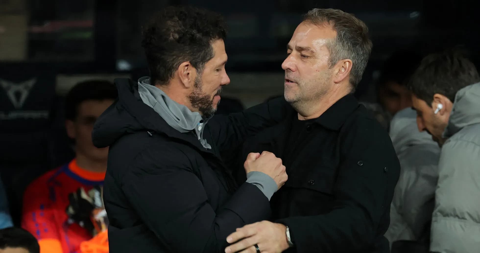 Two coaches embracing on the sidelines