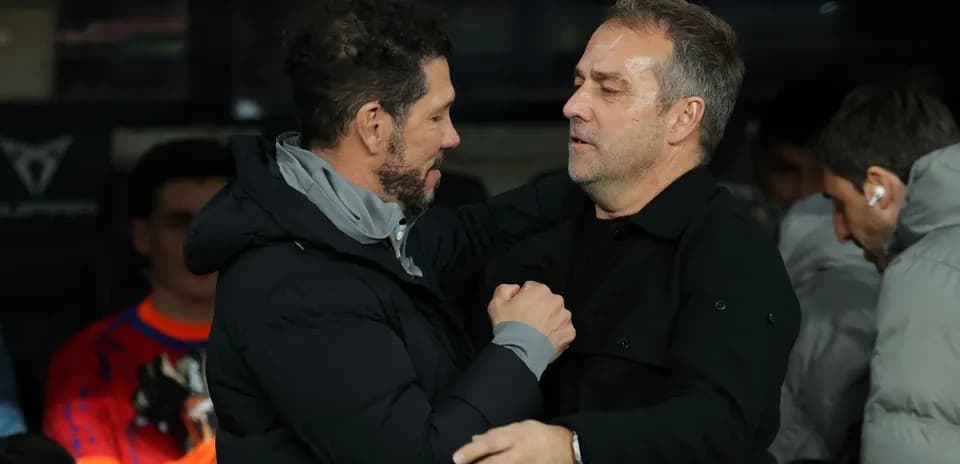 Two coaches embracing on the sidelines
