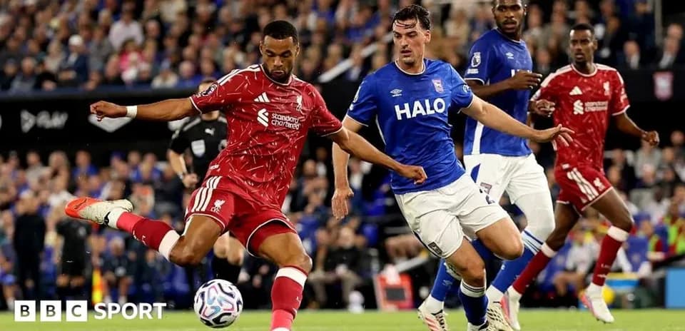 Liverpool player kicking ball past Ipswich defender