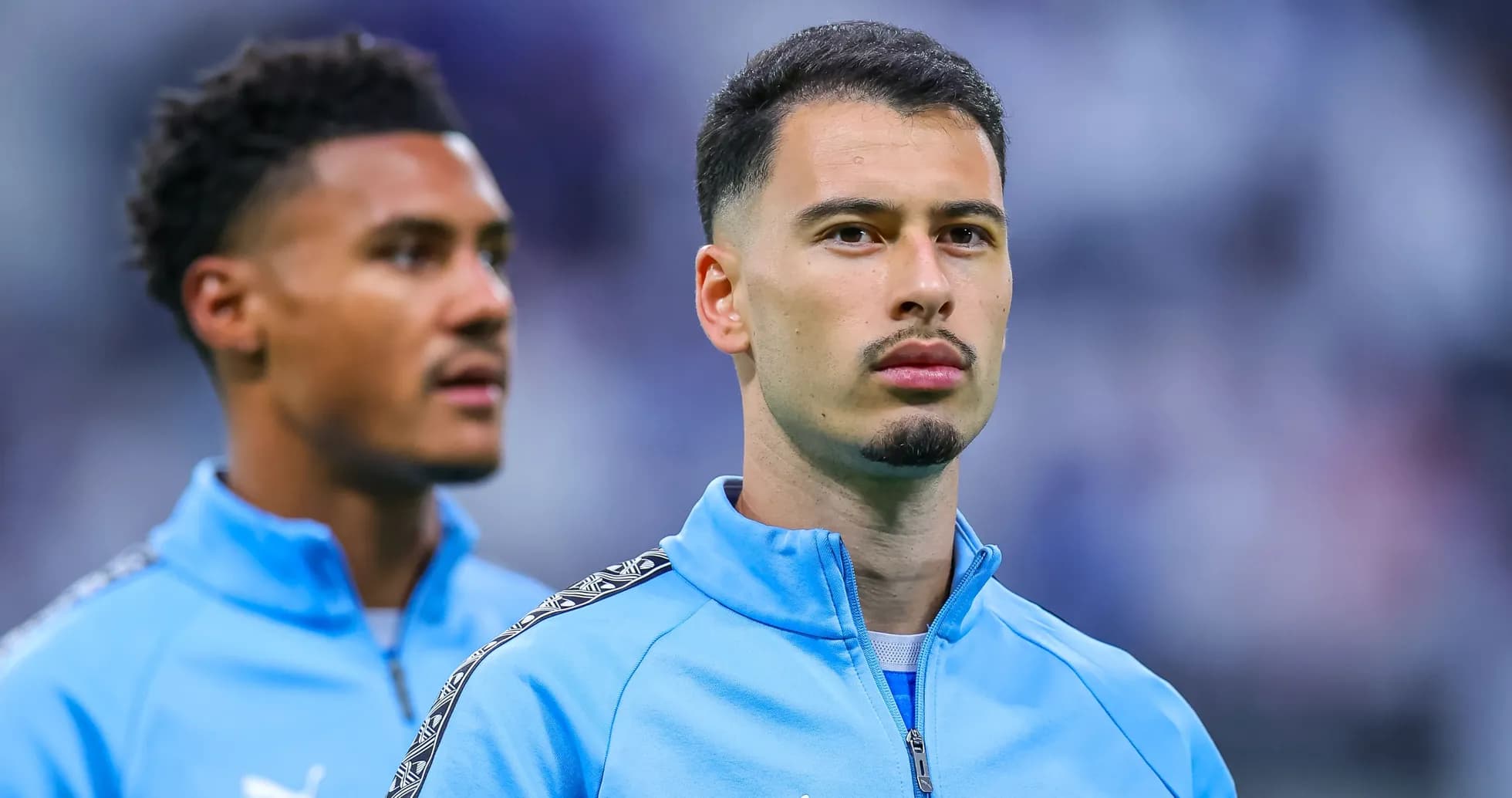 Two players in blue team jackets before match