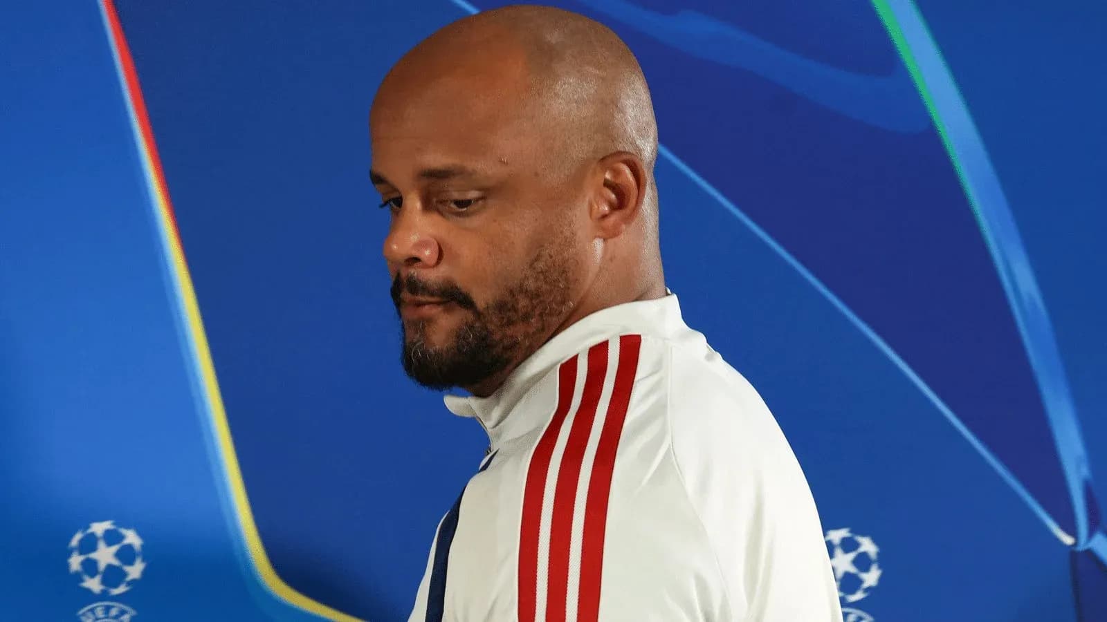 Person in sports attire at press conference backdrop